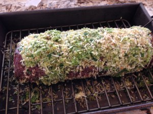 Using a spatula or hands, spread herb paste evenly over the top and sides of the tenderloin.